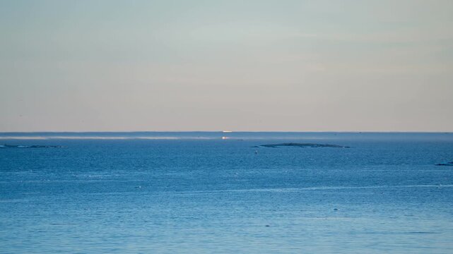 View of Fata Morgana mirages appearing as distorted ships on the horizon over the Gulf of Finland in a timelapse video. Helsinki, Finland.