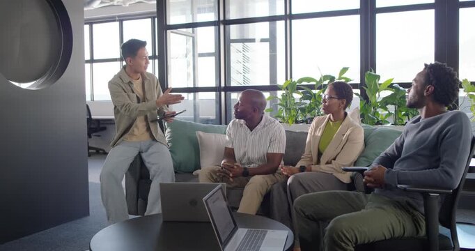 Diverse coworkers listening after presenter opening tablet and outlining points by laptops