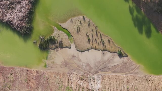 Lysterfield, Australia - 27 August 2026: Aerial view of Boral Quarries showing the green water of the quarry lake, exposed sediment banks, and surrounding rugged terrain.