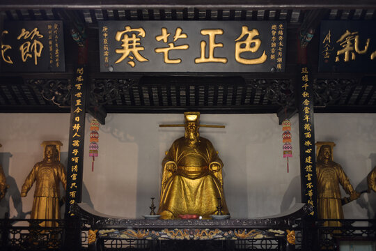 Golden Statues in Traditional Chinese Shrine with Calligraphy