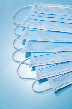Stack of Blue Surgical Masks on Blue Background