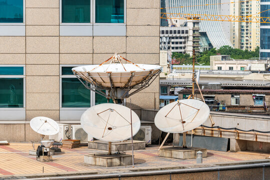 Rooftop satellite dishes and communication antennas in urban cityscape