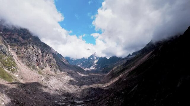 Beautiful Wide Aerial View of the Lahaul and Spiti Mountain Landscape in Himachal Pradesh with Camping Tents, Vast Barren Valleys, Cloud Covered Mountains and Deo Tibba and Indrasan Rising Behind