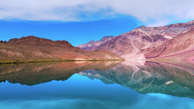 Beautiful Wide Aerial Drone View of Chandratal Lake in Spiti Valley, Himachal Pradesh Showing Vibrant Blue Water, Rugged Mountain Slopes and Clear Sunny Himalayan Weather