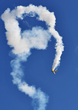 Aerobatic Yellow Airplane Performing Flight with Smoke Trail