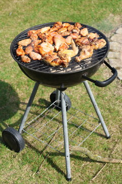 Meat skewers cooking over hot charcoal on an outdoor barbecue