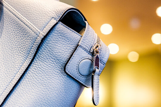 Close-Up View Of The Detail And Corner Stiching And Metallic Zipper Fastening On A Pale Blue Woman's Handbag