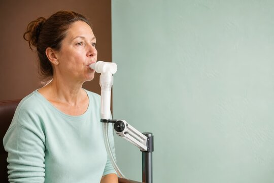 Respiratory therapy woman using a spirometer for breathing test