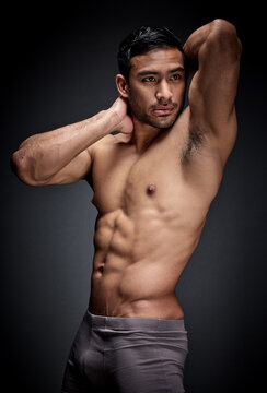Fitness, asian man and body builder flexing abs and strong chest in sexy underwear for exercise in studio. Health, sport and male person with seductive stomach muscles for training on dark background