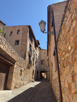 Sunlit cobbled street between stone houses in Alquezar Spain