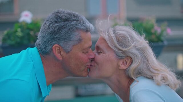 Tender kiss shared by a mature couple outdoors