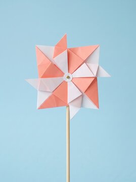 Colorful origami pinwheel against a blue background symbolizing childhood joy and creativity