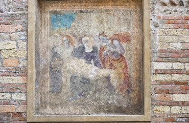 Weathered religious fresco depicting the Virgin Mary mourning Christ in Verona, Italy © S J Lievano