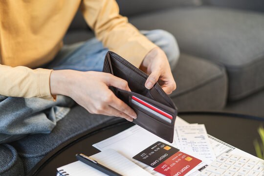 debts in first jobber, Young woman open wallet find it empty with many invoice and credit card on the table
