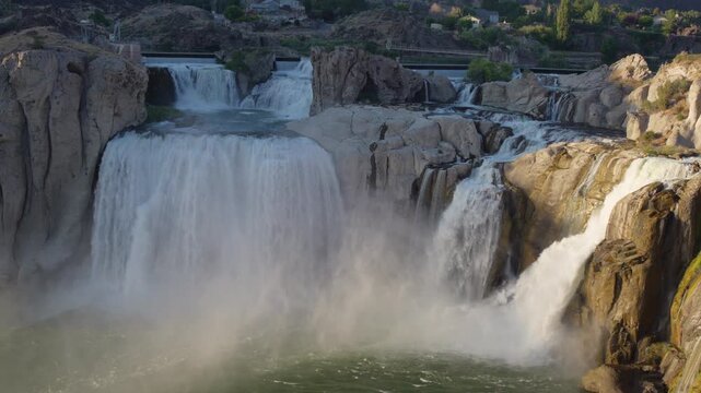View of Shoshone Falls cascading over rocky cliffs with mist rising from the river in Twin Falls County, Idaho, United States.
