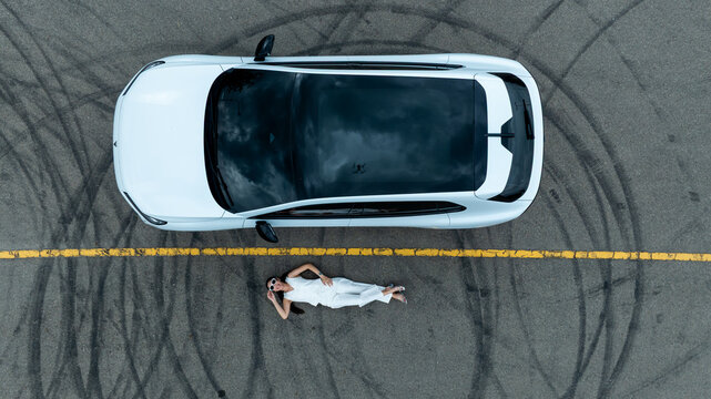 Top view of white ev car.
New ev car on tire marks.
Fast ev car parked on road.