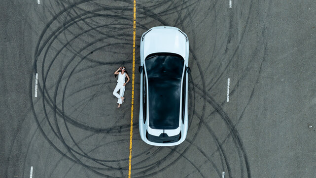Top view of white ev car.
New ev car on tire marks.
Fast ev car parked on road.