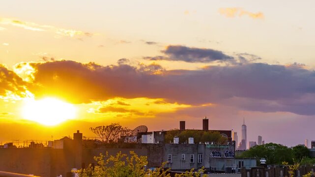 View of sunset over the New York City skyline featuring One World Trade Center and urban rooftops in New York, New York, United States.
