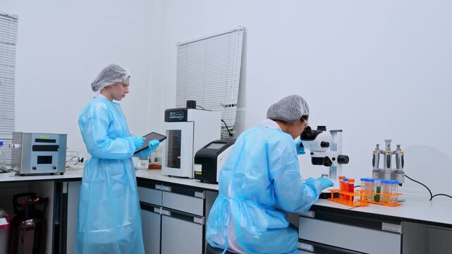 Medical laboratory professionals performing research using high tech microscopes in a sterile and organized setting