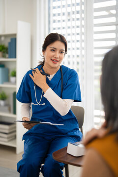 Doctor or nurse visiting elderly female patient at home , filling medical record . Old woman is describing her symptoms to doctor.