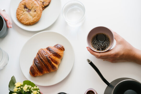 Enjoying Fresh Black Coffee with a Buttery Croissant During a Calm Morning Breakfast at Home