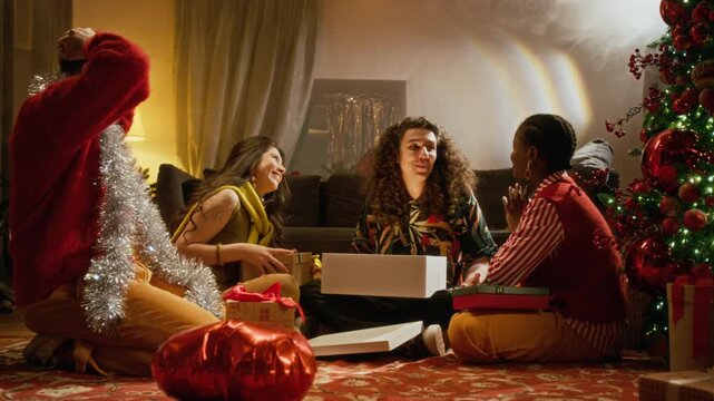 Diverse young adults opening glowing gift box together near Christmas tree during holiday celebration. Perfect for Christmas retail marketing, ecommerce ads, and seasonal unboxing campaigns