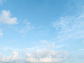 Obraz premium Bright blue tropical sky with soft white cumulus clouds during calm morning weather. Spacious natural background for environmental, seasonal design, weather, climate, nature, wellness concepts.