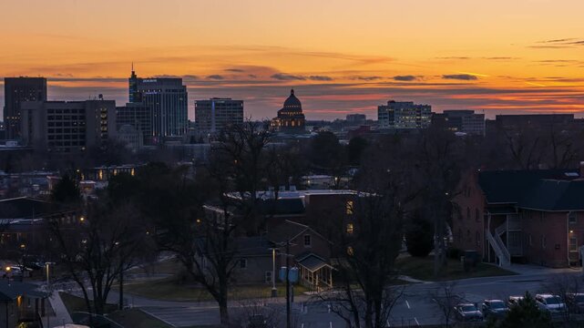 View of the Boise skyline featuring the Idaho State Capitol dome during a vibrant sunset in Boise, Idaho, United States.