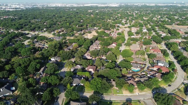 Curved residential pavement connects expansive suburban tracts near MacArthur Boulevard hubs. Deep arboreal cover shelters private parcels throughout sunny Coppell, Texas