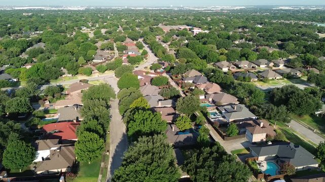 Asphalt roads cut through dense tree canopies within prominent Dallas Fort Worth sectors. Sunlit rooftops accent quiet residential lanes across family communities of Coppell, Texas