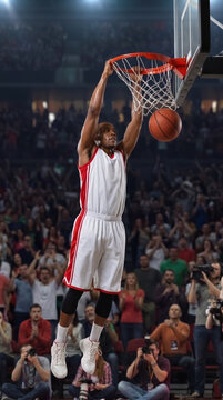 Basketball player dunking in arena