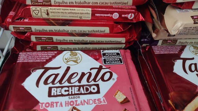 ITABIRA, BRAZIL - SEPTEMBER 2, 2026: Packages of Garoto Talento filled chocolate bars on a store shelf, displaying front-of-pack nutritional warning labels for added sugar and saturated fat.