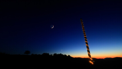 Moon on a twilight sky with stars, planets and landscape mountain silhouettes. © astrosystem