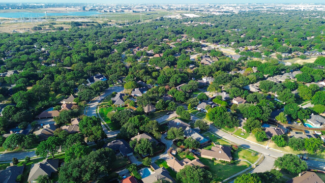 Glistening distant reservoirs border sprawling suburban blocks across quiet NTX parcels. Expansive tree cover buffers charming single family dwellings through Coppell, Texas