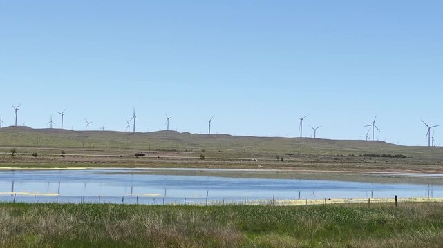 Scenic landscape of salt lake wetland and distant wind turbines in summer in Ulan Hada Volcano Geopark, Ulanqab, Inner Mongolia, China