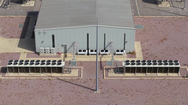 Close up aerial view of rotating cooling fans on high voltage transformer at wind farm substation UK