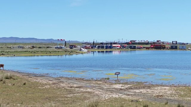 Scenic landscape of salt lake wetland and distant wind turbines in summer in Ulan Hada Volcano Geopark, Ulanqab, Inner Mongolia, China