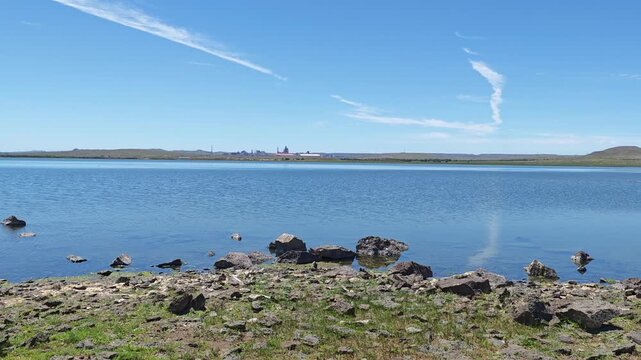 Scenic landscape of salt lake wetland and distant wind turbines in summer in Ulan Hada Volcano Geopark, Ulanqab, Inner Mongolia, China