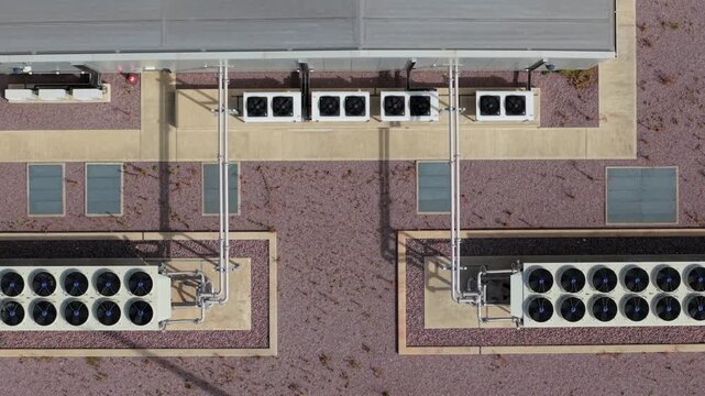 Close up aerial view of rotating cooling fans on high voltage transformer at wind farm substation UK
