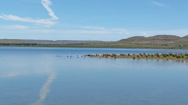 Scenic landscape of salt lake wetland and distant wind turbines in summer in Ulan Hada Volcano Geopark, Ulanqab, Inner Mongolia, China