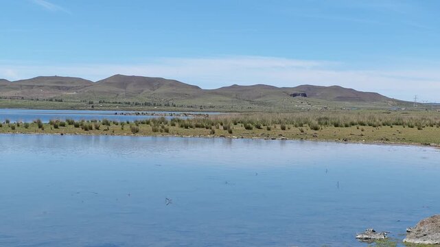 Scenic landscape of salt lake wetland and distant wind turbines in summer in Ulan Hada Volcano Geopark, Ulanqab, Inner Mongolia, China