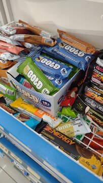 ITABIRA, BRAZIL - AUGUST 31, 2026: Display of various whey protein and dietary supplement bars in a retail grocery store.