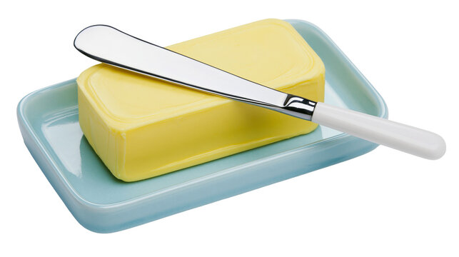Yellow butter block with a silver knife on a light blue butter dish, isolated on transparent background