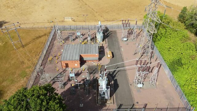 Close up aerial view of high voltage step down transformers and cooling radiators at electrical substation in the UK