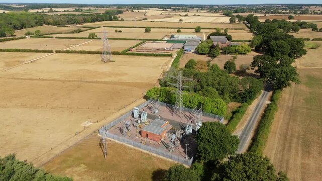 Close-up aerial view of high-voltage 132kV power transformers and electrical switchgear at a rural substation near Bourne, Lincolnshire, UK