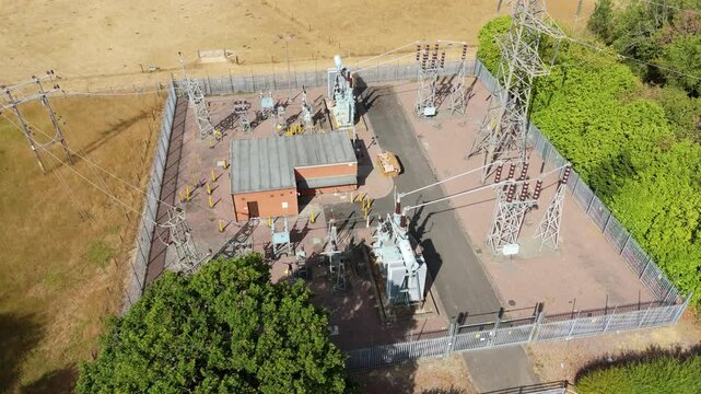Close-up aerial view of high-voltage 132kV power transformers and electrical switchgear at a rural substation near Bourne, Lincolnshire, UK