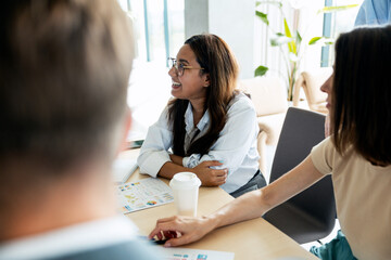 Diverse business team collaborating and laughing during office meeting