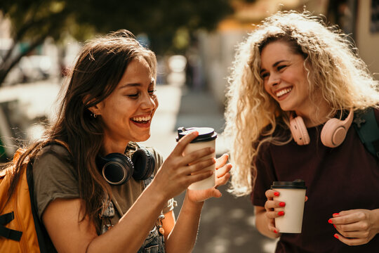 Happy young women enjoying coffee and friendship outdoors