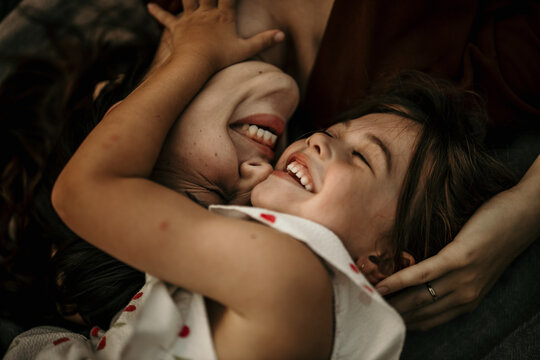 Mother and daughter laughing, sharing a moment of joy