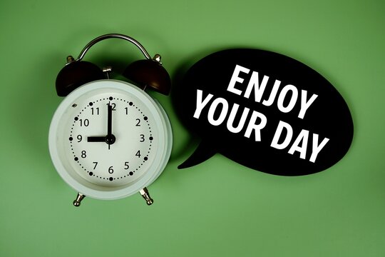 Enjoy Your Day text on speech bubble with alarm clock on green background